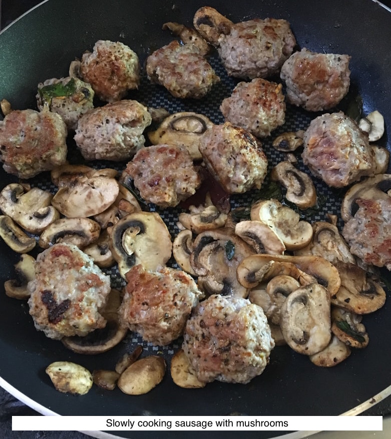 slowly cooking sausage and mushrooms